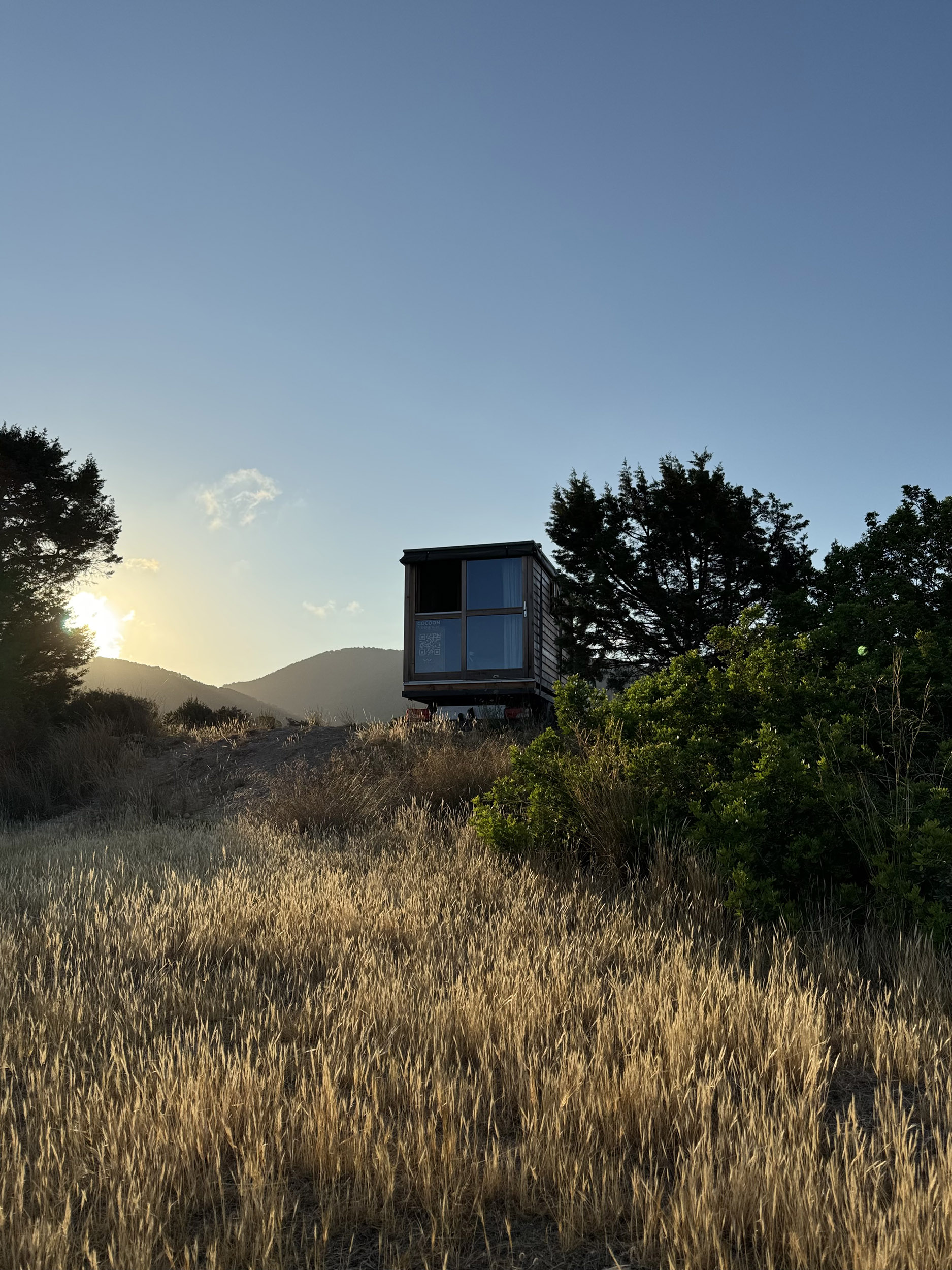 Minimalist mobile house exterior made from eco-friendly Moonwood, designed for health-conscious, sustainable living / Minimalistisches Mobilhaus aus umweltfreundlichem Mondholz, entwickelt für gesundheitsbewusstes und nachhaltiges Wohnen.