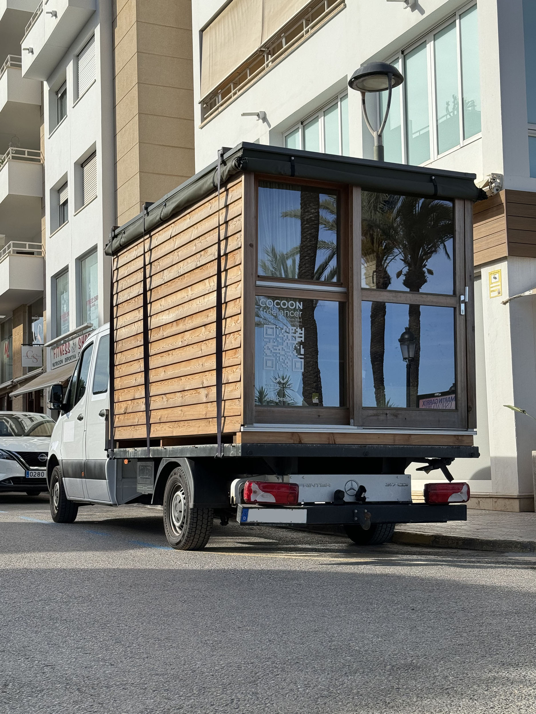 Exterior view of a minimalist design mobile house made from Moonwood, no chemicals or plastic, front view / Außenansicht eines minimalistischen Mobilhauses aus Mondholz, ohne Chemikalien oder Plastik, Vorderansicht.